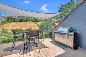 Wooden deck featuring area for grilling and outdoor dining space