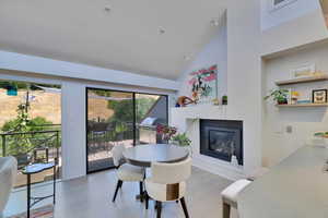 Dining area with a glass covered fireplace and high vaulted ceiling