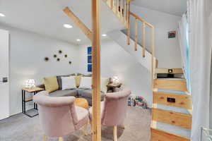 Living area featuring stairway, light carpet, and recessed lighting