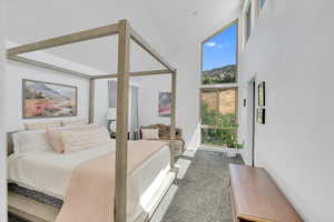 Primary Bedroom featuring carpet flooring and a towering ceiling