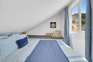 Bedroom with vaulted ceiling and a textured ceiling