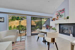 Dining room featuring a glass covered fireplace and high vaulted ceiling