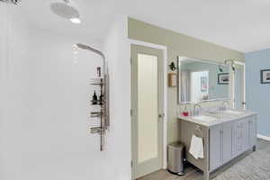 Bathroom with a shower stall, light wood finished floors, and double vanity