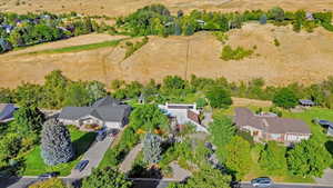 Aerial view of sparsely populated area featuring a tree filled landscape and nearby suburban area