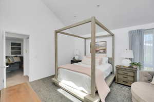 Primary Bedroom with carpet flooring and high vaulted ceiling