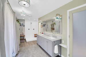 Primary Bathroom featuring double vanity and light wood-style floors
