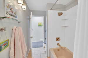 Bathroom featuring light tile patterned flooring and shower / bath combo