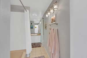 Full bath featuring light tile patterned floors and vanity