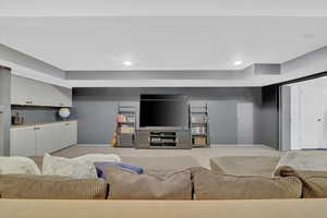 Carpeted living room with baseboards and recessed lighting