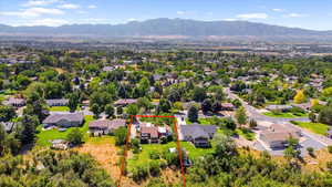 Aerial perspective of suburban area featuring a mountain backdrop and property boundaries highlighted