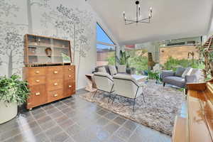 Living room featuring high vaulted ceiling and a chandelier