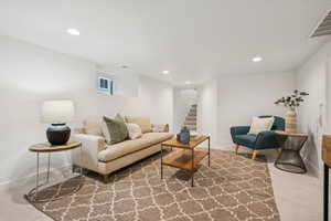 Living room with recessed lighting, light carpet, and stairs