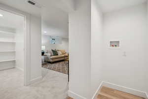 Washroom featuring hookup for a washing machine, recessed lighting, light wood-style floors, and light colored carpet