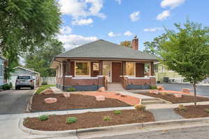 Bungalow-style home featuring covered porch, a shingled roof, brick siding, and driveway