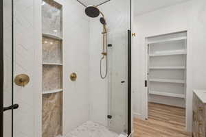 Bathroom with a stall shower, light wood-type flooring, and vanity