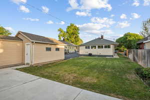 Rear view of house featuring a lawn and a patio