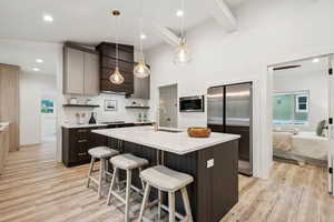 Kitchen with dark brown cabinets, open shelves, a breakfast bar, recessed lighting, and beamed ceiling