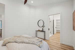 Bedroom with light wood-type flooring, a spacious closet, and recessed lighting