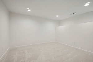 Empty room featuring light carpet and recessed lighting