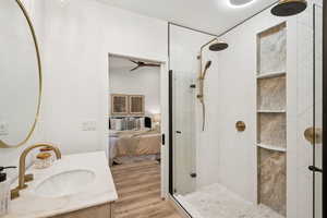 Ensuite bathroom with a shower stall, vanity, and light wood-type flooring