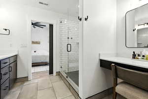 Bathroom featuring vanity, a stall shower, light tile patterned floors, and connected bathroom