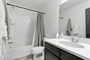 Bathroom featuring shower / bath combo with shower curtain, light tile patterned floors, and vanity