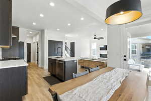 Kitchen with a center island with sink, open floor plan, recessed lighting, light wood-style flooring, and stainless steel dishwasher