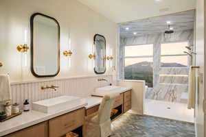 Full bathroom with a marble finish shower, two vanities, a wainscoted wall, and recessed lighting