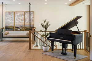 Living area featuring an upstairs landing, light wood-style flooring, recessed lighting, and beamed ceiling