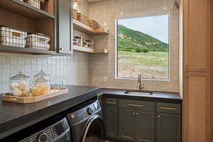 Washroom featuring washer and dryer, cabinet space, and a mountain view
