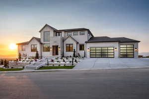 View of front of house featuring an attached garage, driveway, and brick siding