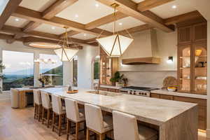 Kitchen featuring light stone counters, a large island, tasteful backsplash, glass insert cabinets, and arched walkways