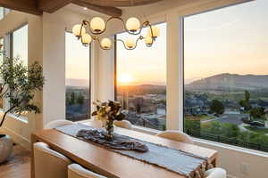 Dining space featuring plenty of natural light, a chandelier, a mountain view, beamed ceiling, and wood finished floors