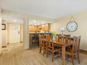 Dining area with recessed lighting and light wood finished floors