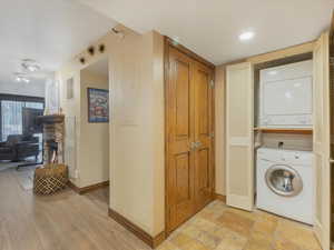 Laundry room with stacked washer / dryer and baseboards