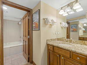Full bathroom #1 featuring light tile patterned floors, vanity, and bathtub / shower combination