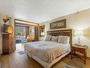 Bedroom with wood finished floors and access to outside