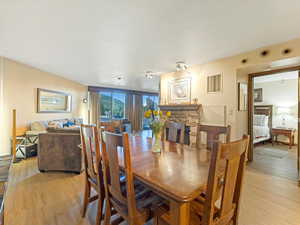 Dining space featuring light wood-type flooring and a fireplace
