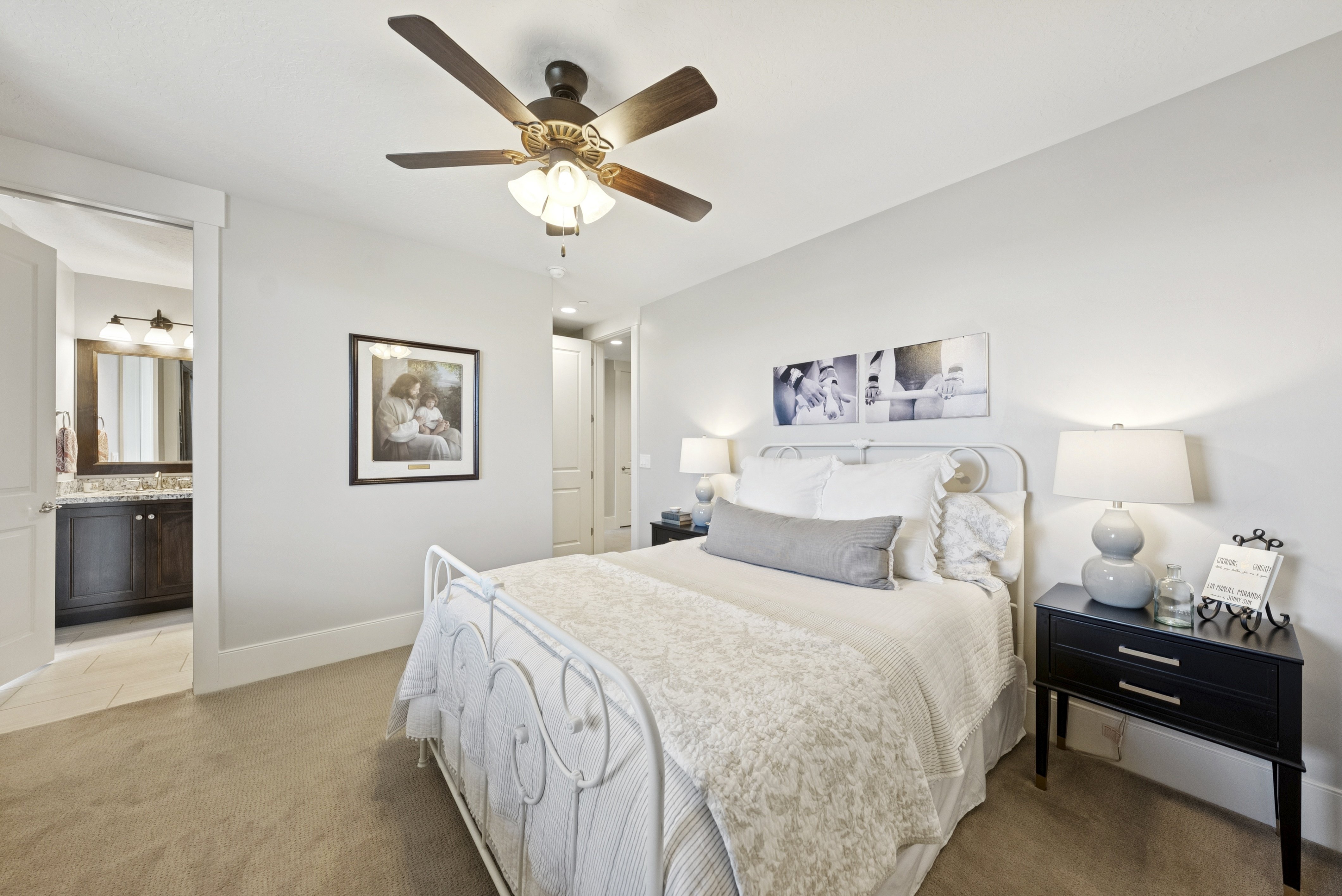 Bedroom featuring light colored carpet, ceiling fan, and ensuite bath