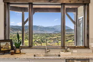 Kitchen view of light stone counters and decorative backsplash