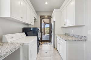 Laundry room featuring independent washer and dryer, light tile patterned flooring, recessed lighting, and cabinet space