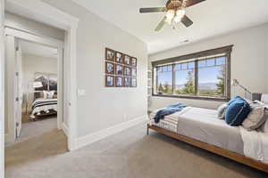 Carpeted bedroom featuring baseboards and a ceiling fan