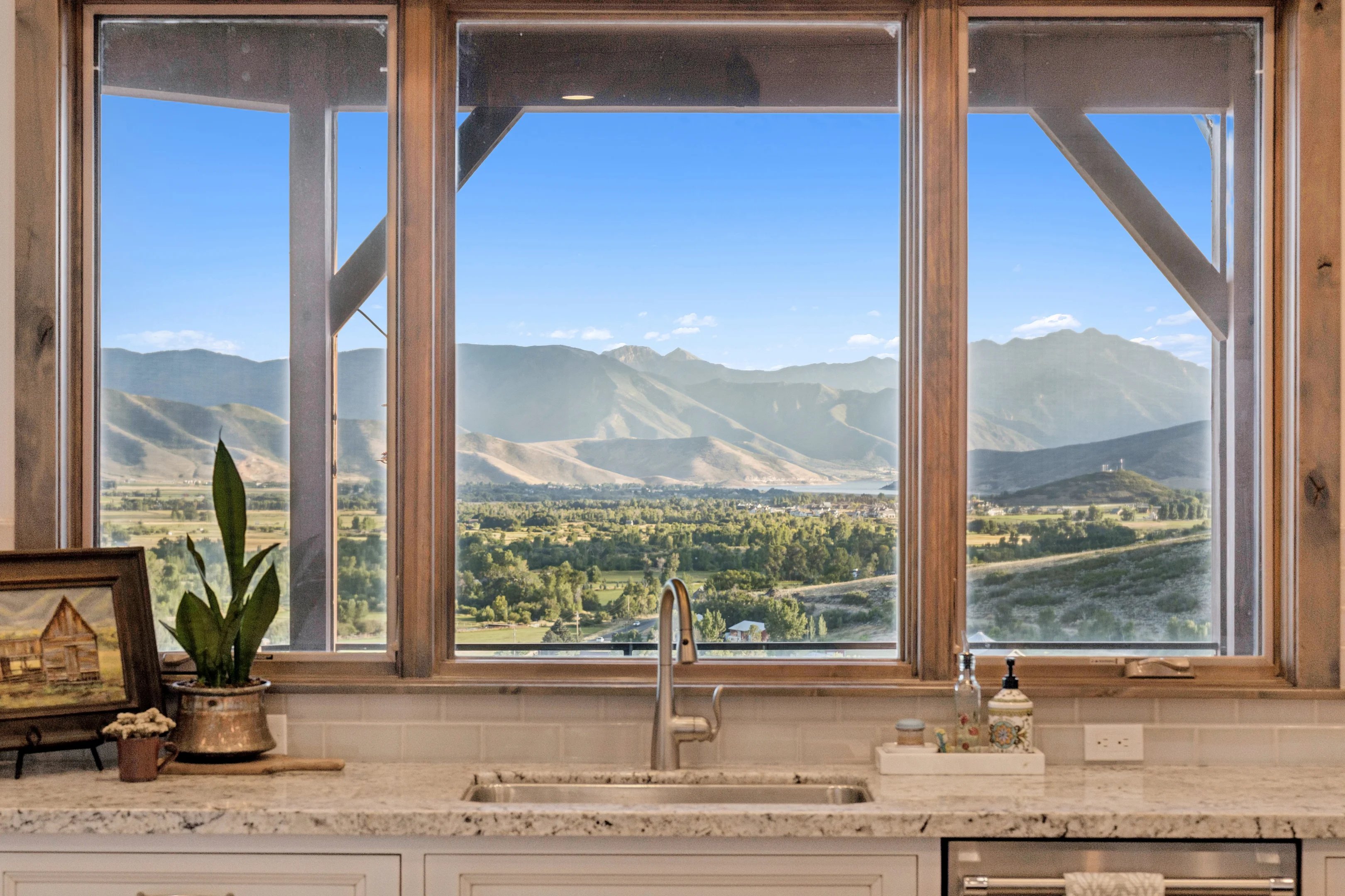 Kitchen view of light stone countertops and decorative backsplash