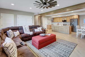 Living area featuring recessed lighting, beam ceiling, light wood-style floors, stairway, and ceiling fan