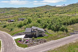 View from above of property featuring a mountain backdrop and a heavily wooded area