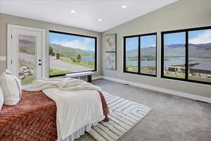 Bedroom with lofted ceiling, light colored carpet, recessed lighting, a water and mountain view, and access to outside
