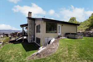 Back of property featuring a yard, a chimney, stairs, and a mountain view