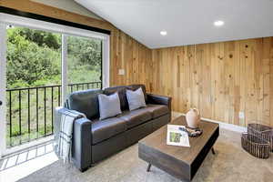Living area featuring recessed lighting, carpet, and wooden walls