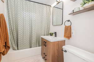 Bathroom featuring shower / bath combination with curtain and vanity