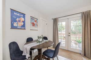 Tiled dining space featuring french doors